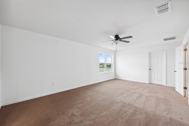 carpeted empty room with visible vents, ceiling fan, and baseboards