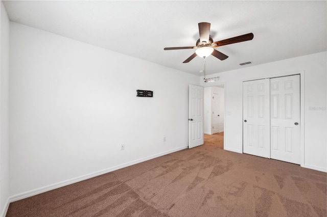 unfurnished bedroom with carpet floors, baseboards, visible vents, and a closet