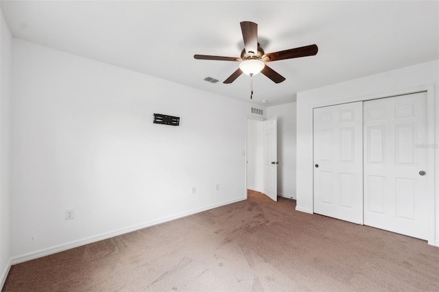 unfurnished bedroom with carpet floors, a closet, visible vents, and baseboards