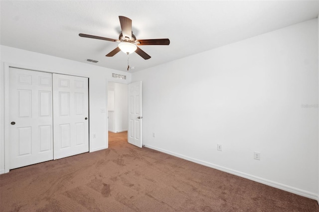 unfurnished bedroom with a closet, carpet flooring, visible vents, and baseboards