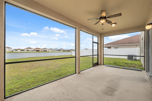 unfurnished sunroom with a water view, ceiling fan, and a residential view