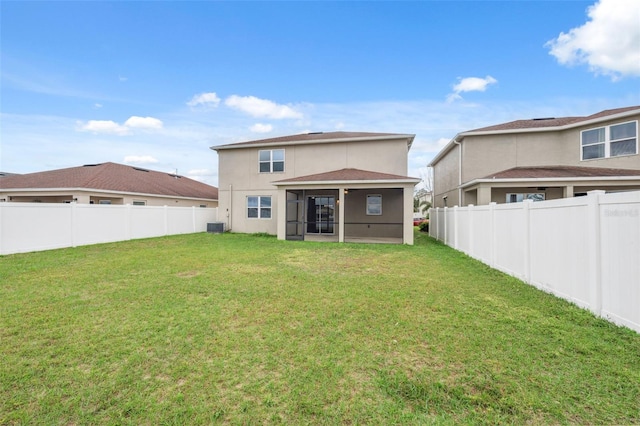 back of property with central air condition unit, a fenced backyard, a yard, and stucco siding