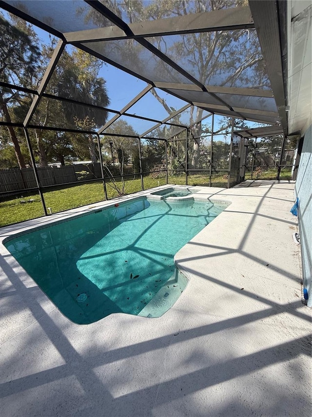 view of pool featuring a lawn, a pool with connected hot tub, a patio, fence, and a lanai