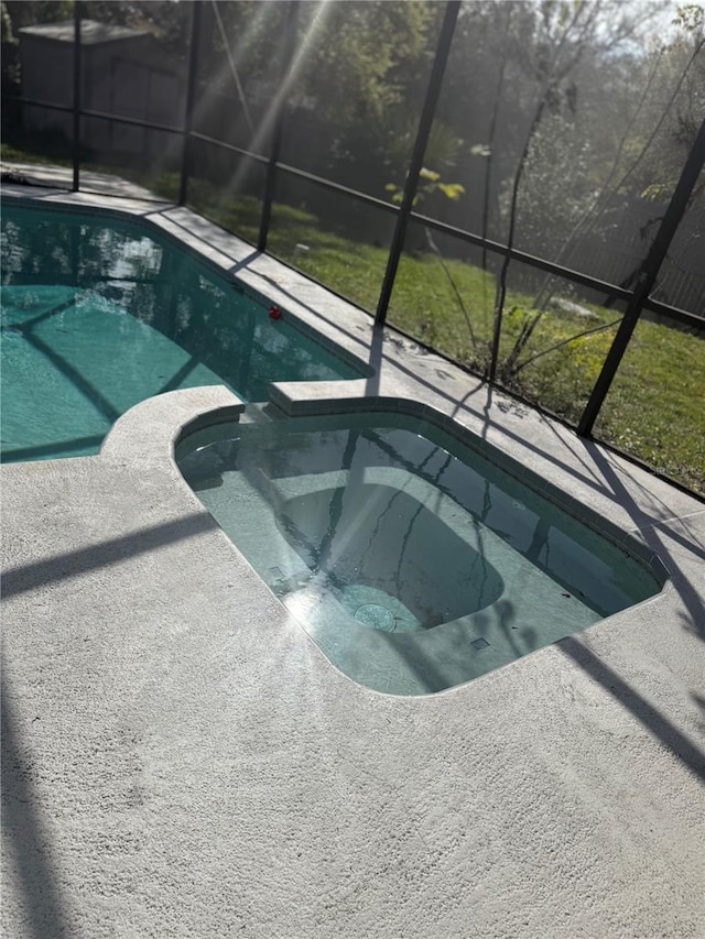 view of swimming pool featuring a patio, a lanai, and a pool with connected hot tub