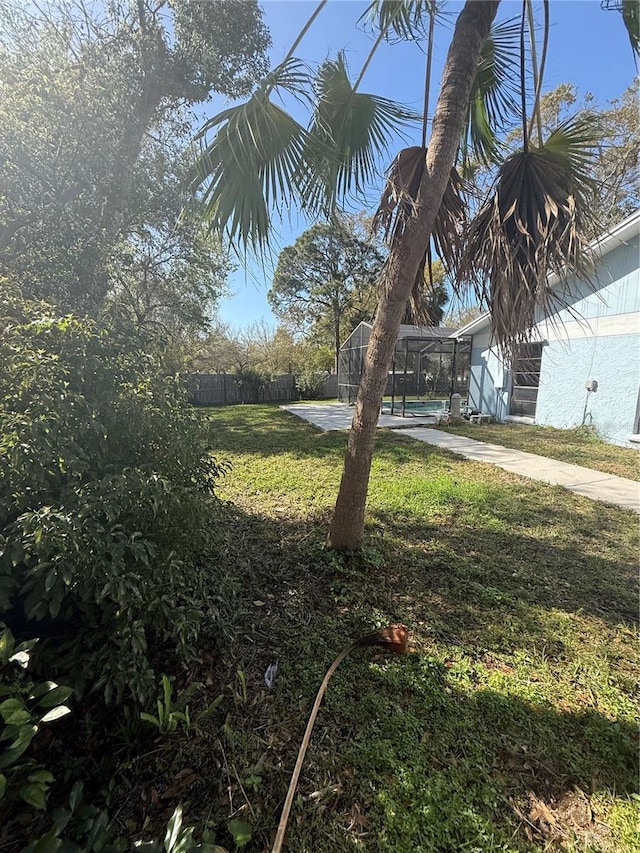 view of yard featuring a pool, a lanai, and fence