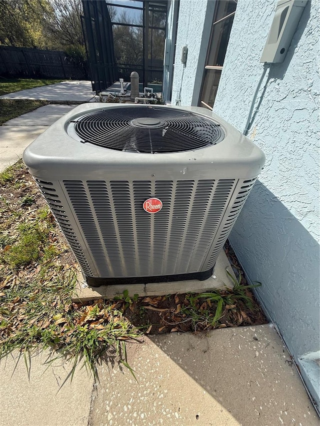 details with central AC unit, fence, and stucco siding