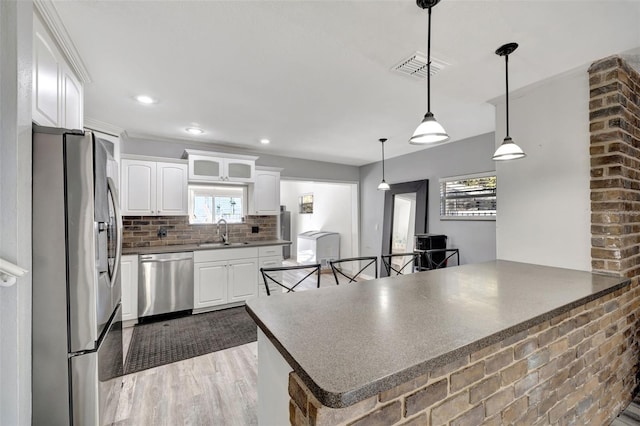 4716 Gazania St, New Port Richey, FL 34652 - kitchen with decorative backsplash, dark countertops, appliances with stainless steel finishes, a peninsula, and a sink