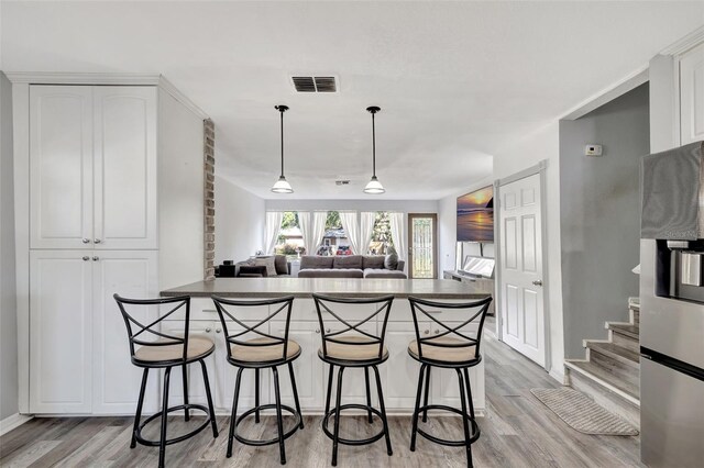 4716 Gazania St, New Port Richey, FL 34652 - kitchen with a peninsula, white cabinetry, and a kitchen breakfast bar