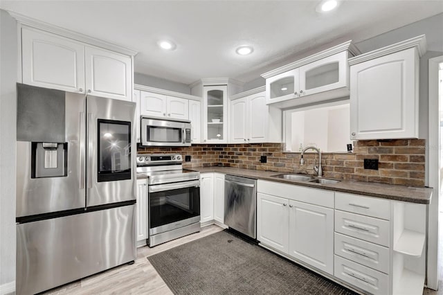 4716 Gazania St, New Port Richey, FL 34652 - kitchen with white cabinets, dark countertops, glass insert cabinets, stainless steel appliances, and a sink