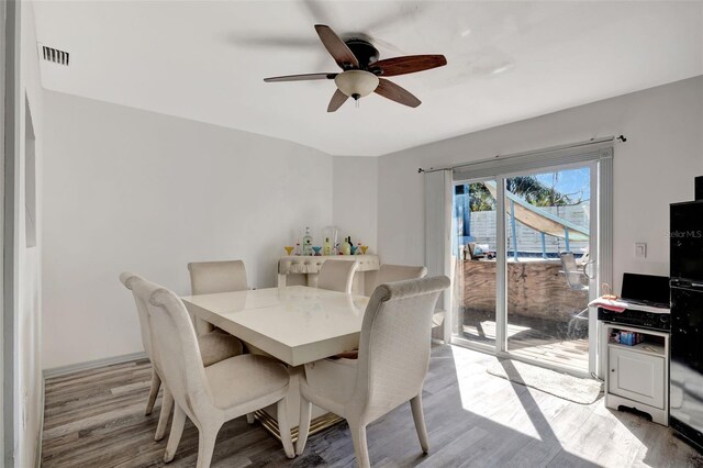 4716 Gazania St, New Port Richey, FL 34652 - dining space with visible vents, ceiling fan, and wood finished floors