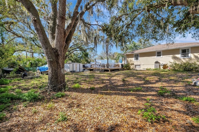 4716 Gazania St, New Port Richey, FL 34652 - view of yard featuring a shed, a deck, and an outbuilding
