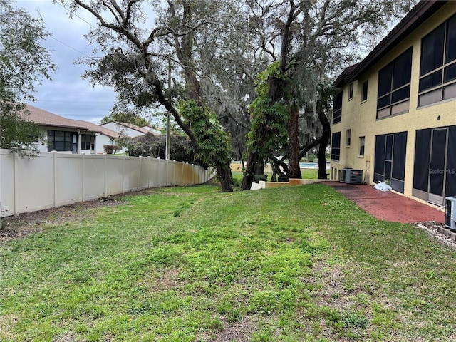 view of yard with fence and central air condition unit