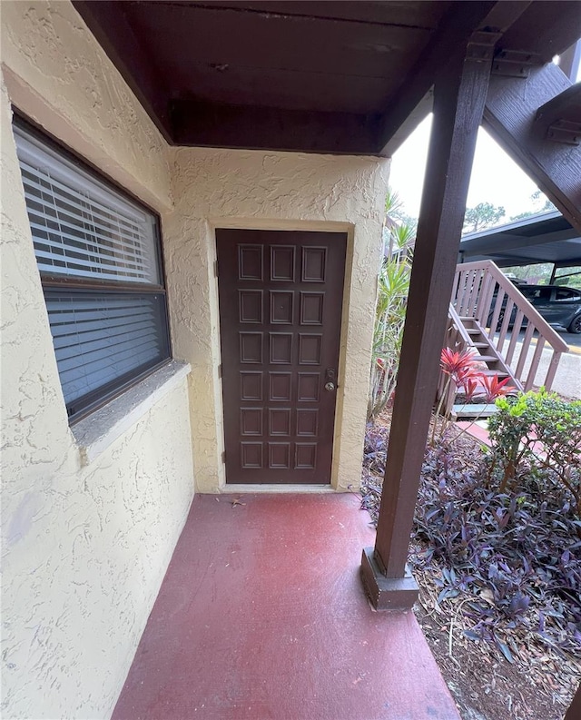 doorway to property featuring stucco siding