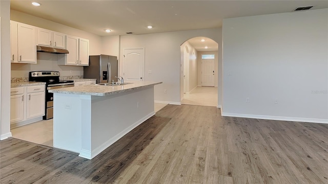 kitchen with arched walkways, stainless steel appliances, under cabinet range hood, and white cabinets