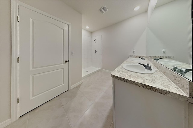 full bath featuring a stall shower, tile patterned flooring, visible vents, and a sink