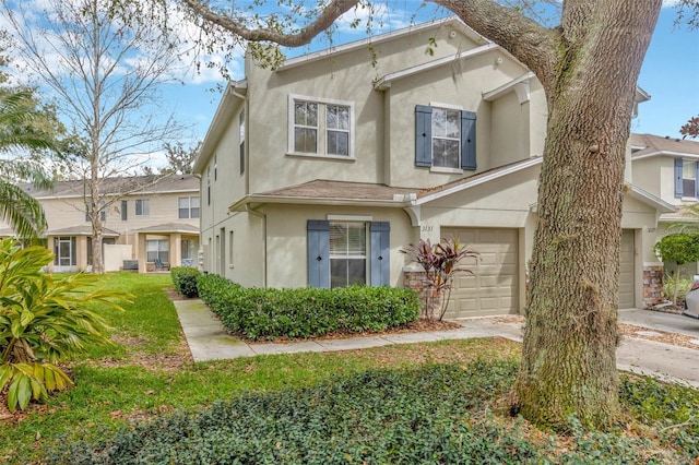 view of front of home featuring a front lawn, driveway, an attached garage, and stucco siding