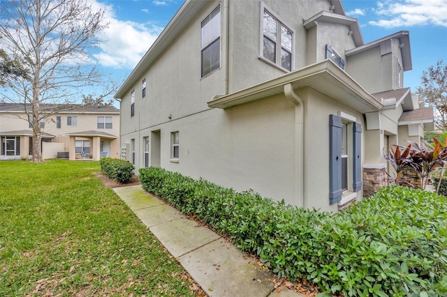 view of property exterior featuring a lawn and stucco siding