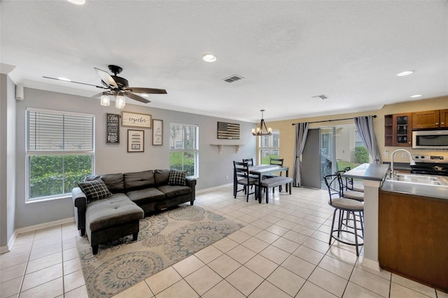 living room with ornamental molding, visible vents, and light tile patterned flooring