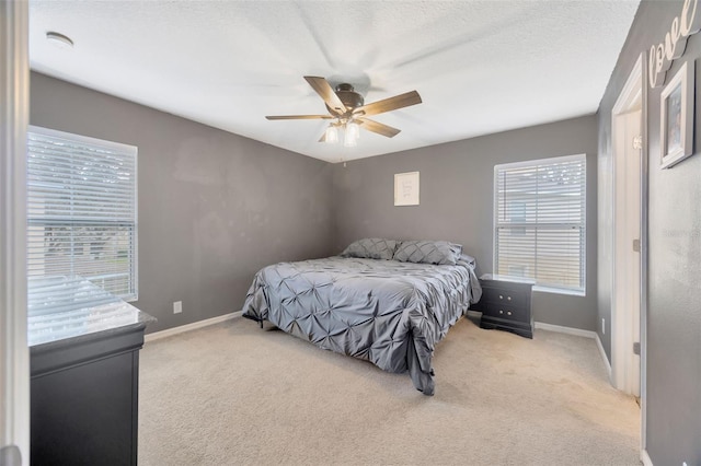 bedroom with light colored carpet, baseboards, and multiple windows