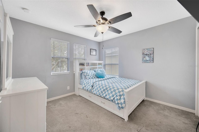 bedroom featuring baseboards, a ceiling fan, and light colored carpet