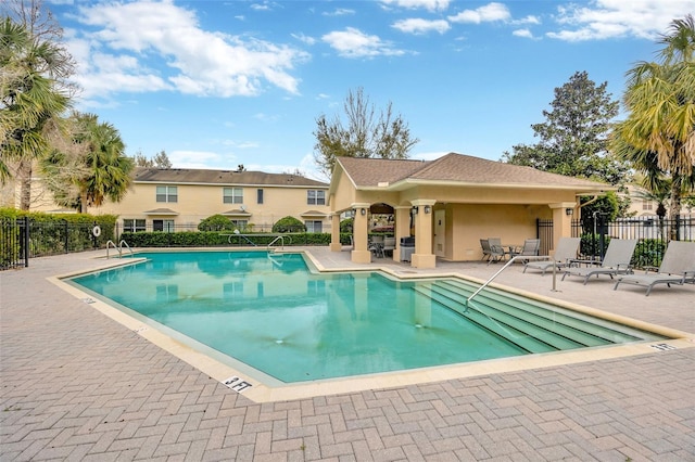 pool with fence and a patio