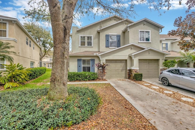 view of front of house with driveway, an attached garage, and stucco siding