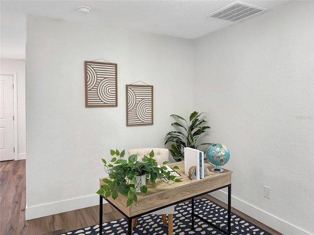 office space featuring visible vents, baseboards, and wood finished floors