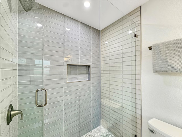 full bathroom with a stall shower and toilet