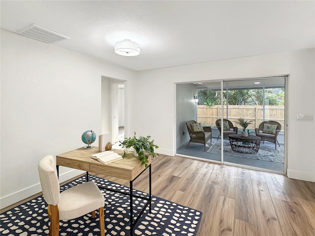 home office featuring wood finished floors, visible vents, and baseboards