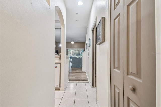 hall with light tile patterned floors and arched walkways