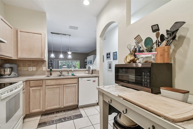 kitchen with white appliances, light brown cabinets, a sink, and backsplash