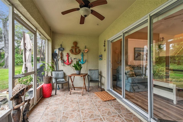 unfurnished sunroom with a ceiling fan