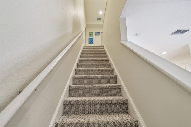 stairway with visible vents and baseboards