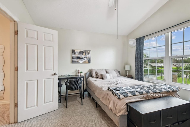 bedroom with lofted ceiling, light carpet, and baseboards