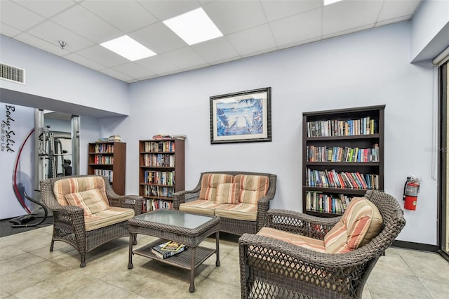 sitting room featuring a drop ceiling, visible vents, and light tile patterned floors