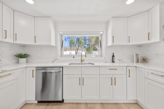 kitchen featuring a sink, white cabinetry, backsplash, and stainless steel dishwasher