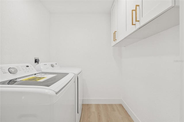 washroom featuring baseboards, light wood-style flooring, cabinet space, and washer and dryer