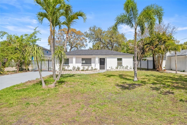 view of front facade with a front lawn, fence, and stucco siding