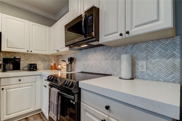 kitchen with light countertops, white cabinets, stainless steel microwave, and range with electric stovetop