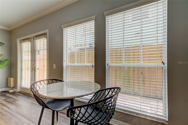 dining room featuring ornamental molding, wood finished floors, and baseboards