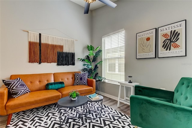 living area with ceiling fan, baseboards, and wood finished floors