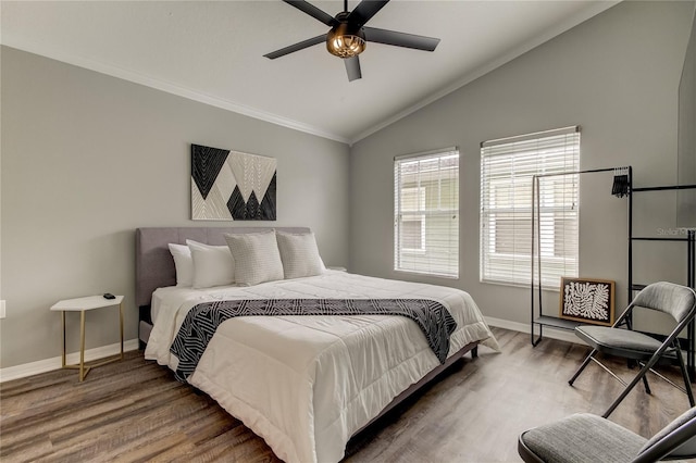 bedroom featuring ornamental molding, vaulted ceiling, ceiling fan, wood finished floors, and baseboards