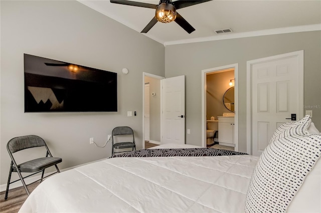 bedroom with crown molding, visible vents, vaulted ceiling, and ensuite bathroom