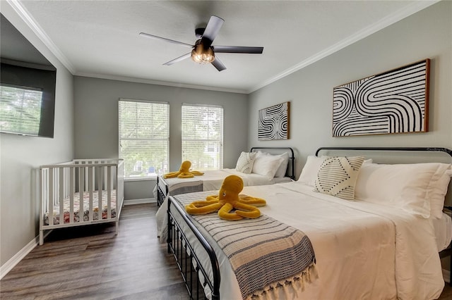 bedroom featuring ornamental molding, dark wood-type flooring, a ceiling fan, and baseboards