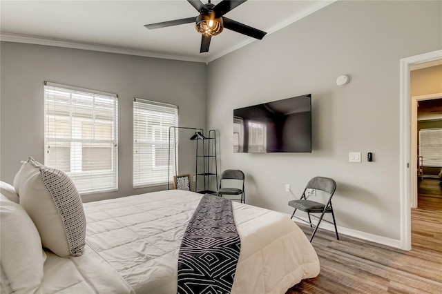 bedroom featuring light wood-style floors, baseboards, ornamental molding, and ceiling fan