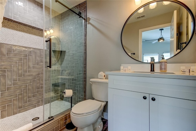 bathroom featuring visible vents, toilet, ceiling fan, vanity, and a shower stall