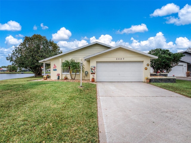 ranch-style home with a garage, a front yard, concrete driveway, and a water view