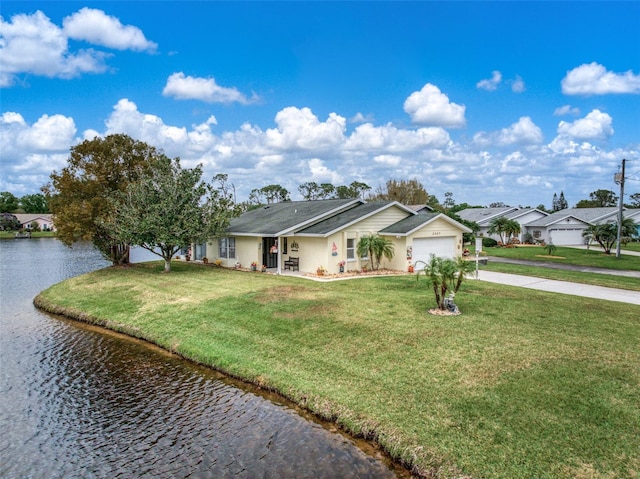 ranch-style house featuring an attached garage, a water view, a front lawn, and concrete driveway