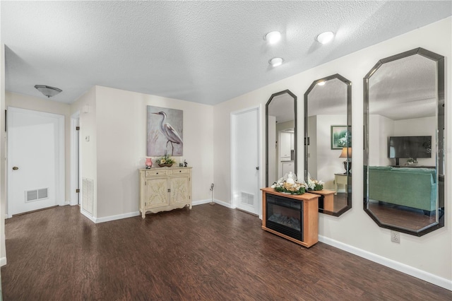 interior space with baseboards, visible vents, and wood finished floors