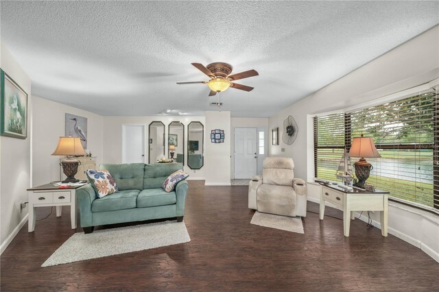 living room with a textured ceiling, wood finished floors, a ceiling fan, and baseboards